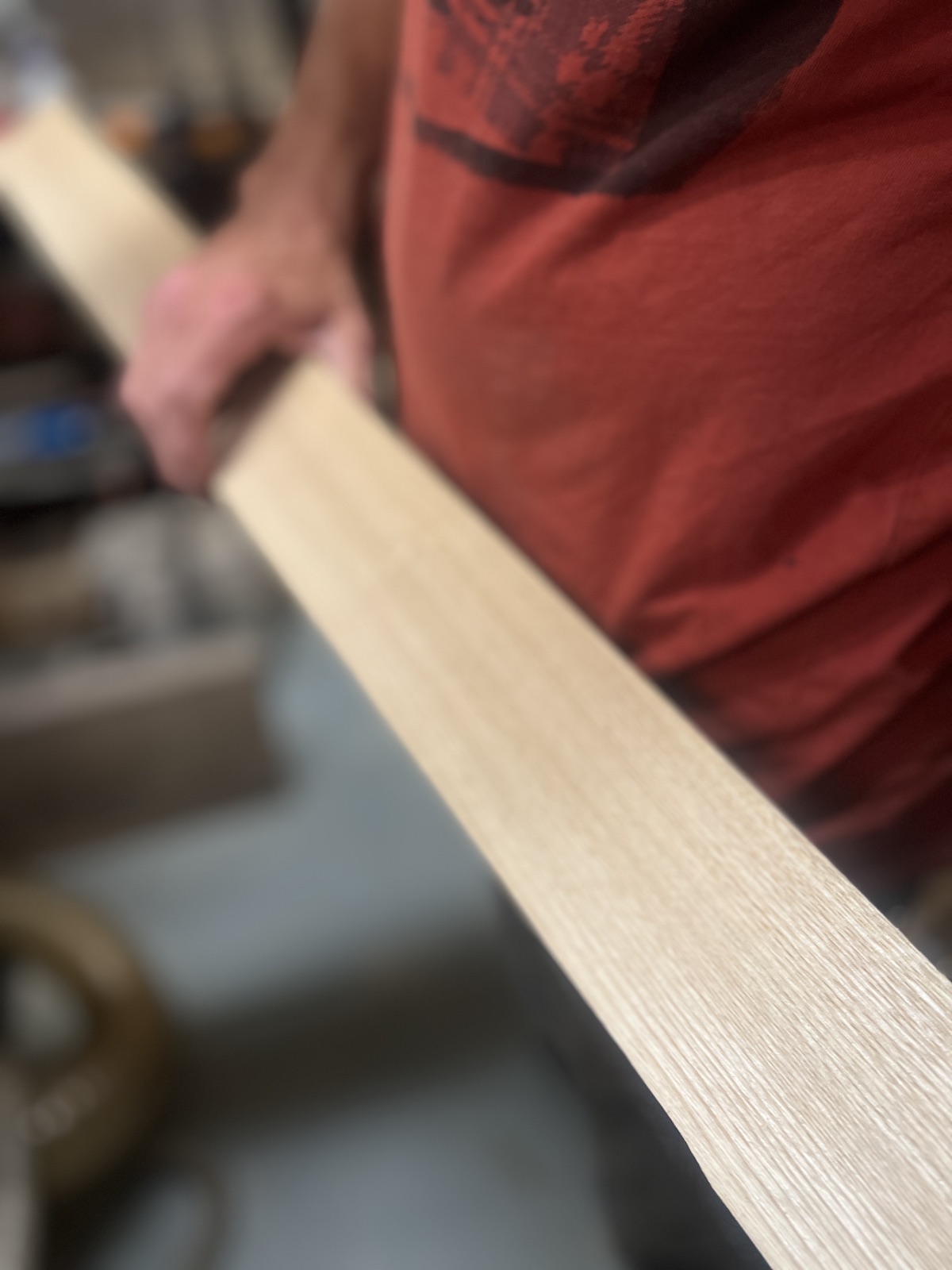 Reading the grain of a pale sawn board held up to the workshop light